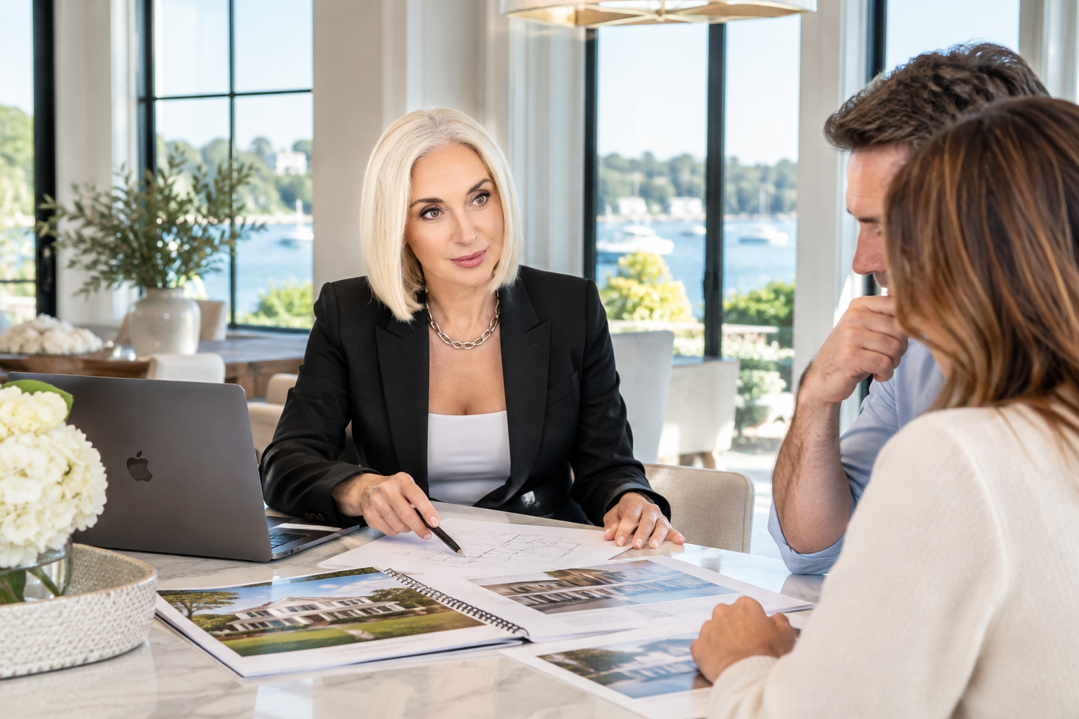 Real estate agent Irina Baskakova reviewing property listings and homebuying costs with prospective buyers inside a luxury waterfront home in Greenwich, CT.